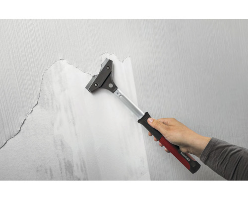 Behangschraper in gebruik om behang van een muur te verwijderen