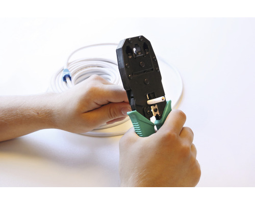 Een persoon gebruikt een krimptang met een netwerkkabel.