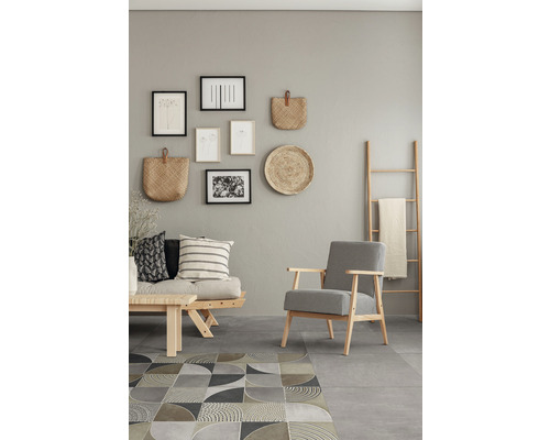 Woonkamer met bank, fauteuil, tapijt en wanddecoraties