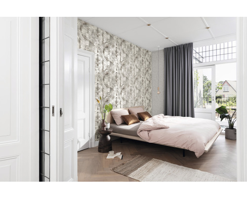 Lichte slaapkamer met bed, patroonbehang, gordijnen en houten vloer