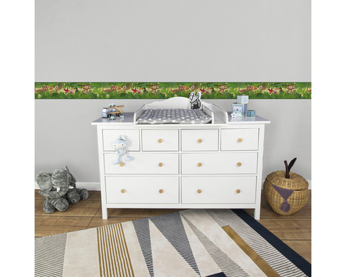 Kinderkamer met commode, rand, tapijt en speelgoed