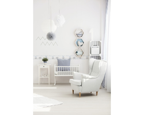Lichte kinderkamer met wieg, fauteuil en decoratieve elementen