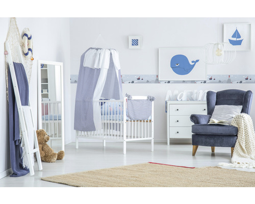 Babykamer in maritieme stijl met ledikant, fauteuil en bijpassende decoratie