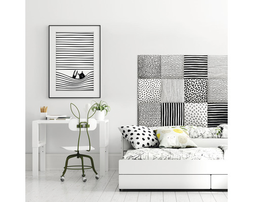 Inrichting van een kamer met bureau, stoel en bed in zwart-wit.