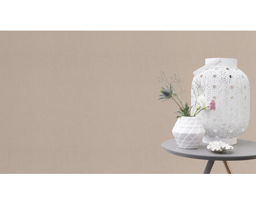 Decoratieve scène met een witte lantaarn, een vaas met bloemen en een kleine decoratie op een tafel