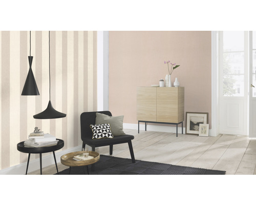 Woonkamer met gestreept behang, dressoir, fauteuil en hanglampen