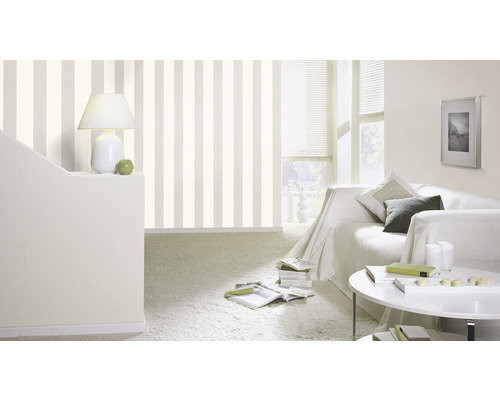 Woonkamer met gestreept behang, bank en tafel.