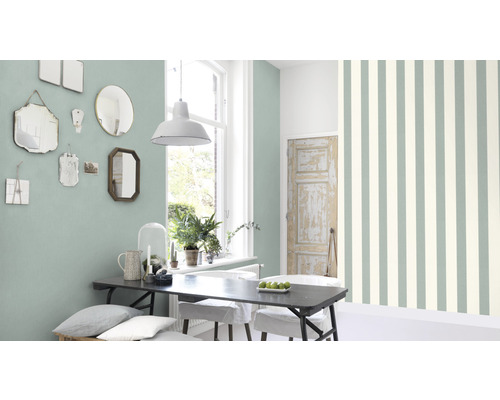 Lichte kamer met eettafel, spiegels aan de wand en gestreept behang