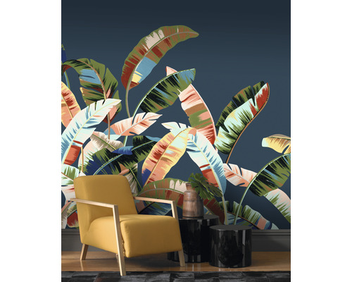 Woonkamer met patroonbehang, fauteuil en bijzettafels