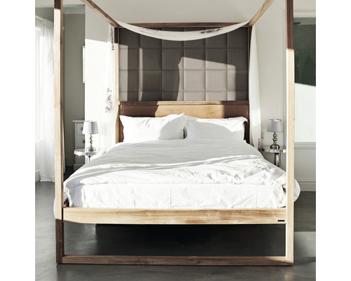 Bed met hemel, beddengoed en gestoffeerd hoofdeinde in slaapkamer