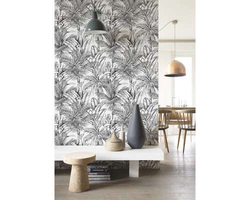 Woonkamer met witte bank, decoratieobjecten, kruk en palmenbehang