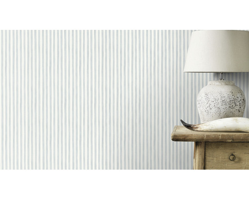 Behang met gestreept patroon in de kamer, met een lamp op een houten tafel