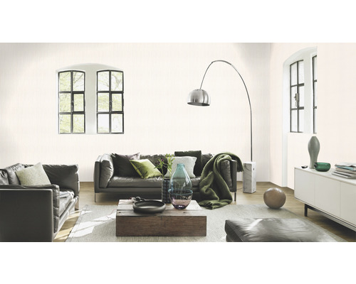 Woonkamer met leren banken, houten tafel en subtiel gedessineerd behang.