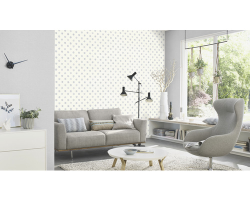 Woonkamer met bank, stoel en behang met stippenpatroon