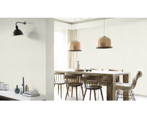 Lichte eetkamer met houten tafel, stoelen en wandlamp