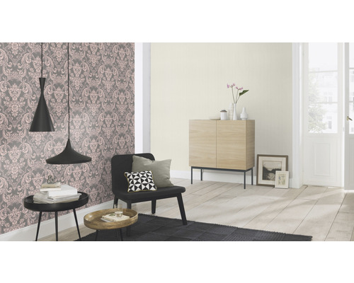 Woonkamer met bloemenbehang, fauteuil, bijzettafels en houten kast