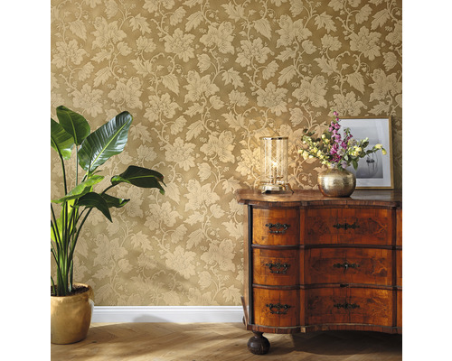 Decoratieve kamer met bloemenbehang, ladekast, tafellamp en kamerplant.