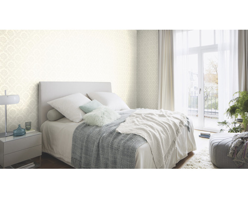 Lichte slaapkamer met bed, nachtkastje en behang met patroon