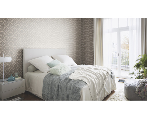 Slaapkamer met patroonbehang, bed en nachtkastje