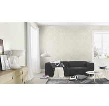 Woonkamer met patroonbehang, bank en decoratieve elementen voor een gezellige sfeer