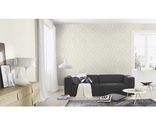 Woonkamer met patroonbehang, bank en decoratieve elementen voor een gezellige sfeer