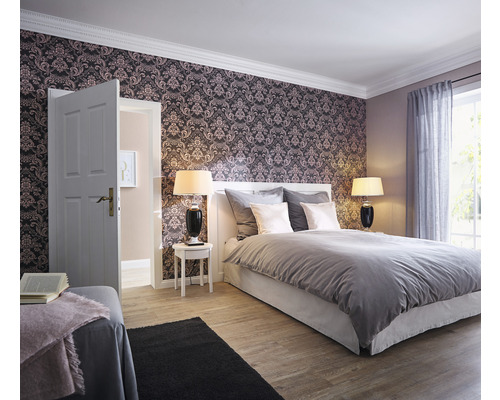 Slaapkamer met behang met patroon, bed, nachtkastjes en lampen.