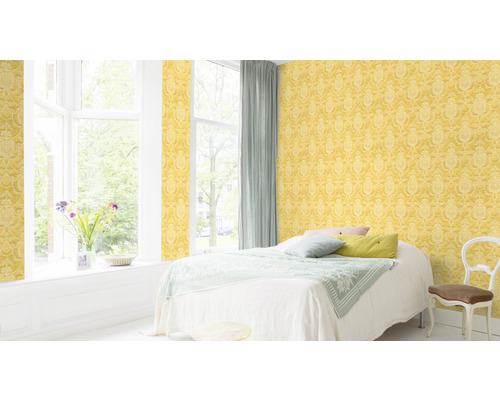 Lichte slaapkamer met geel, patroonbehang, bed en raam