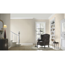 Woonkamer met fauteuil, staande lamp en boekenkast