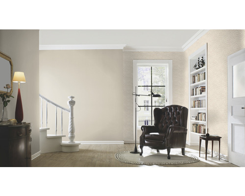 Woonkamer met fauteuil, staande lamp en boekenkast