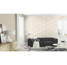 Woonkamer met behang met bladerenmotief, bank en woonaccessoires.