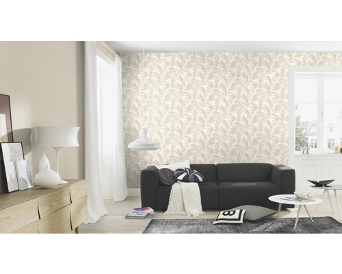 Woonkamer met behang met bladerenmotief, bank en woonaccessoires.