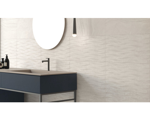 Moderne badkamer met wastafel, spiegel en wandtegels met golfpatroon.