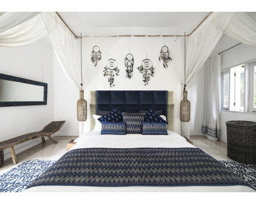 Slaapkamer met tweepersoonsbed, nachtlampen, dromenvangers en blauw textiel