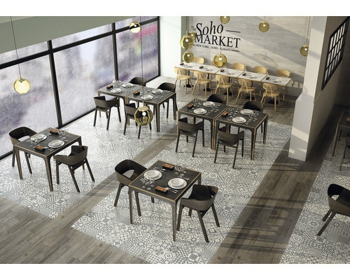 Interieur van een restaurant met tafels en stoelen op een vloer met patroontegels.