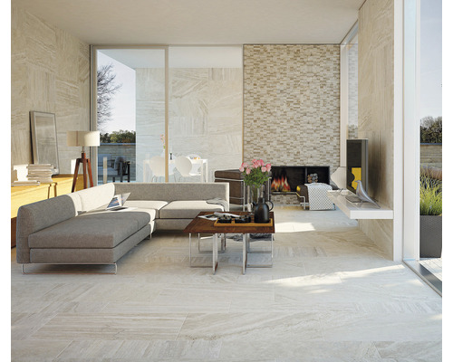 Lichte woonkamer met tegelvloer, bank en open haard.