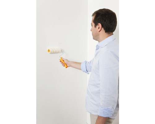 Man schildert muur met verfroller