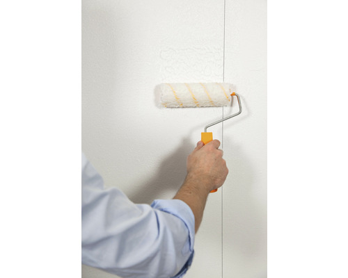 Een persoon verft een muur met een verfroller.