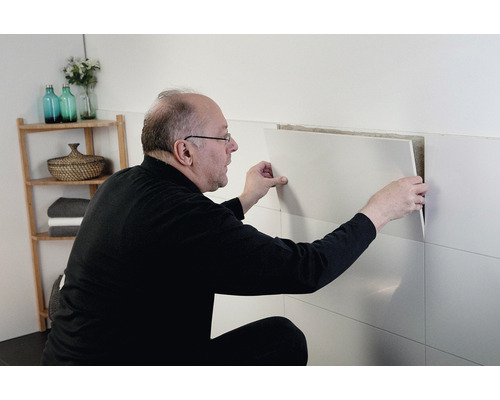 Man tegelt een badkamermuur.