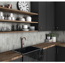 Moderne keuken met zwarte kasten, houten planken, marmeren wasbak en grijze tegels