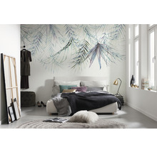 Slaapkamer met een bed, een vloerkleed en een wand met bladerenbehang