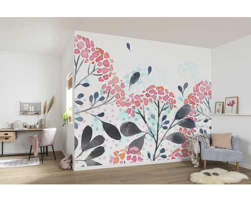 Woonkamer met bloemen fotobehang, bureau en fauteuil.