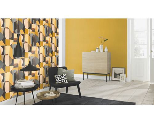 Woonkamer met een patroonbehang, commode en zitplaats