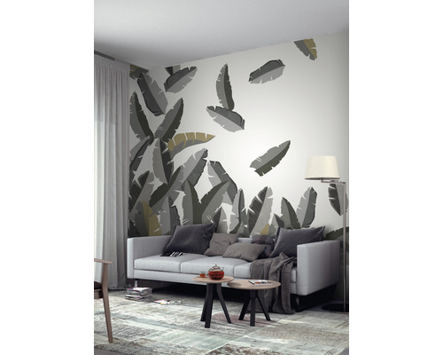 Woonkamer met behang met bladerenmotief, bank, tafel en staande lamp