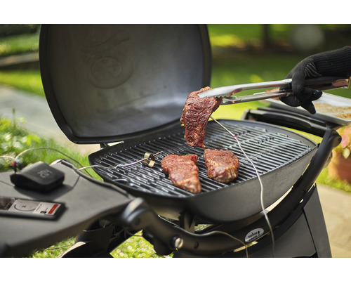 Barbecuescène met steaks op de grill en een barbecue-tang met een steak