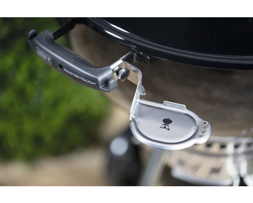 Detailopname van een houtskoolbarbecue met Weber logo en houder