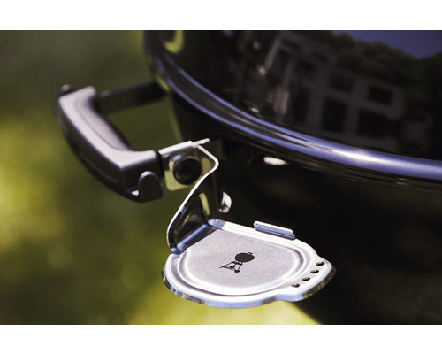 Detailopname van een bolvormige barbecue met open asopvangbak en Weber logo