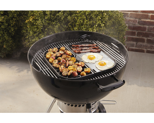 Weber barbecue met ontbijtingrediënten zoals aardappelen, spek en spiegeleieren.
