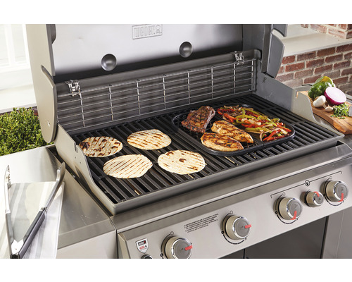 Weber barbecue met gegrild voedsel, waaronder platbrood, steak, kip en groenten.