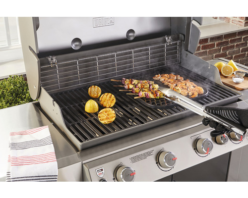 Weber barbecue met gegrilde etenswaren zoals citroenen, spiesen en garnalen