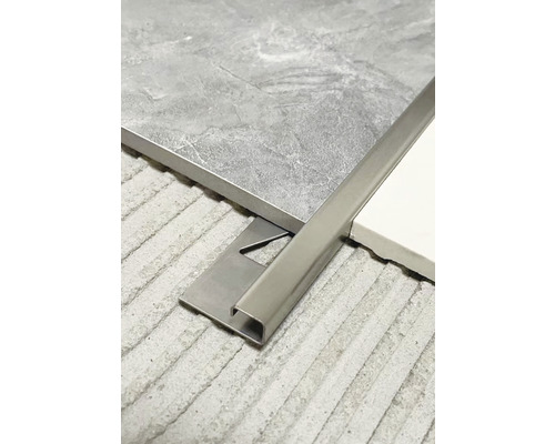 Metalen tegelstrip tussen twee tegels